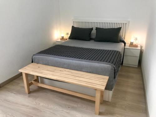 een slaapkamer met een bed en een houten bank bij Teixidors de Palomar - PalomarGroup in Valencia