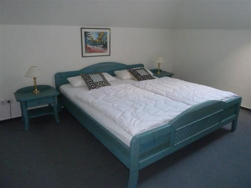 a bed in a room with two tables and two lamps at Villa Nadine, gemütliche Ferienwohnung in Zingst