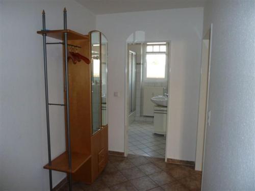 a bathroom with a wooden cabinet and a mirror at Villa Nadine, gemütliche Ferienwohnung in Zingst