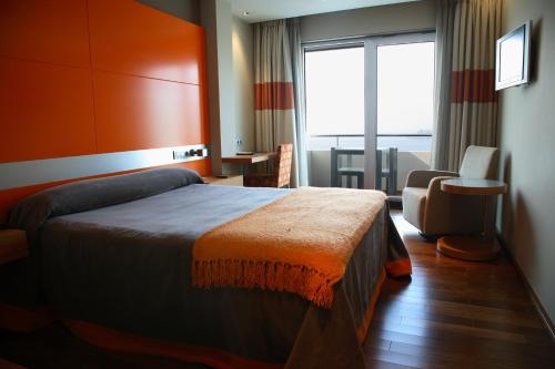 a hotel room with a bed and a chair at Hotel Ego in Viveiro