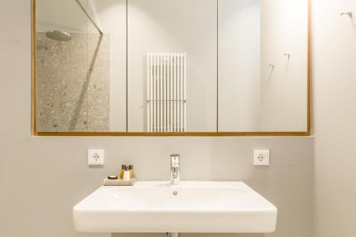 a bathroom with a white sink and a mirror at OSTKÜSTE - Nadler Hof Design Apartments in Ahlbeck