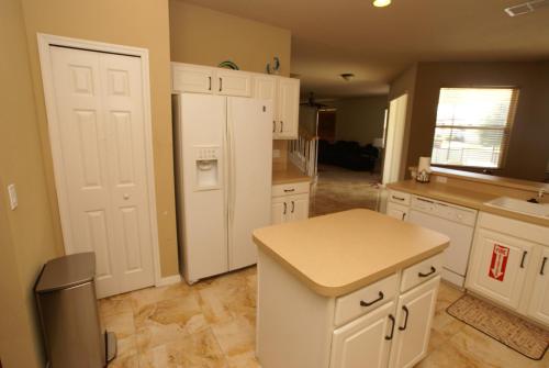 a kitchen with white cabinets and a white refrigerator at VILLA ORLANDO CHARM in Davenport