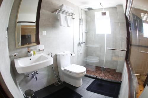 a bathroom with a toilet and a sink and a shower at City Hotel Colombo 02 in Colombo