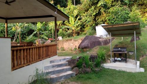 a backyard with a grill and a wooden deck at Precious Residence C in Grand'Anse