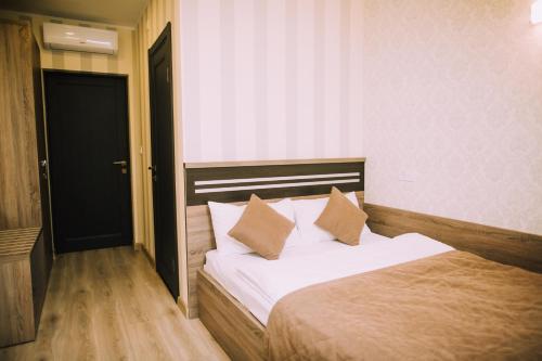 a bedroom with a bed with white sheets and pillows at Bolero plus in Mukacheve