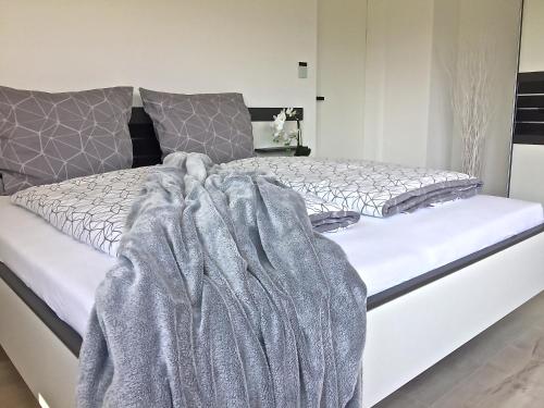 a bedroom with a bed with a blanket on it at Ferienwohnung Black White in Raubling