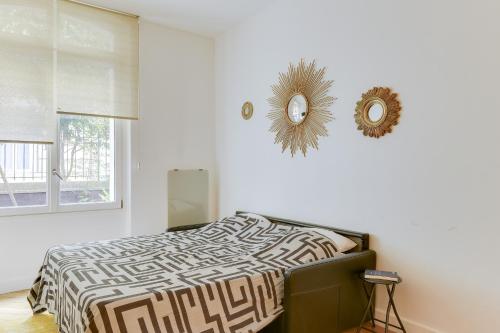 une chambre avec un lit et un miroir au mur dans l'établissement 21a Maréchal FOCH Avenue Paris CHAMPS-ELYSÉES, à Paris