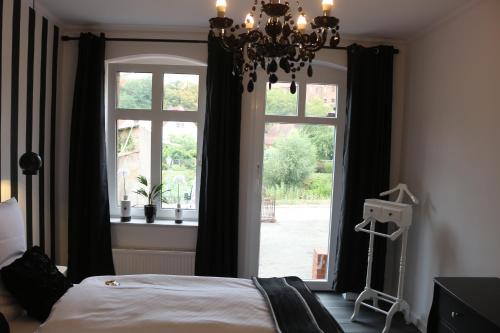 a bedroom with a bed and a window with a chandelier at Dompanorama- Luxuriöse FeWo in Havelberg
