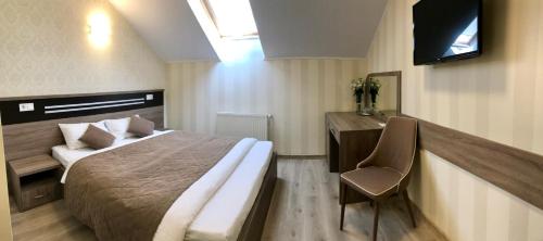 a bedroom with a bed and a desk and a television at Bolero plus in Mukacheve