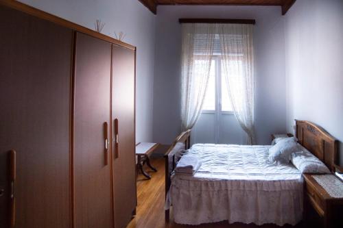 een slaapkamer met een bed en een groot raam bij Rakel in Muros