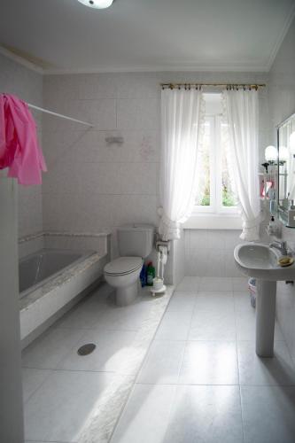 ein Badezimmer mit Badewanne, Toilette und Waschbecken in der Unterkunft Rakel in Muros