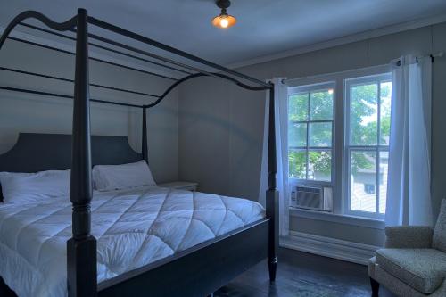 a bedroom with a canopy bed and a window at Charlevoix House in Charlevoix