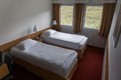 a hotel room with two beds and two windows at Hotel Skaftafell in Skaftafell