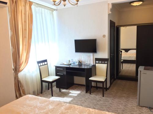 a bedroom with a desk and chairs and a bed at Vesta Guest House in Kislovodsk