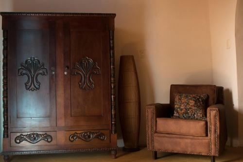 a wooden cabinet next to a chair and a chair at Buriti EcoH RNT56521, via Termales Santa Rosa de Cabal in Santa Rosa de Cabal