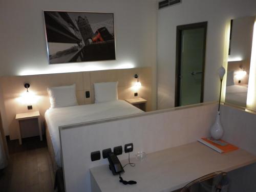 a hotel room with a bed and a mirror at Ibis Styles La Louvière in La Louvière