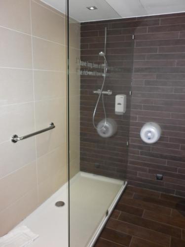 a shower with a glass door in a bathroom at Ibis Styles La Louvière in La Louvière