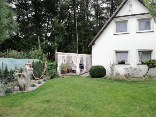 a white house and a yard with a yard at Pokoje, apartament NA WYSPIE in Gdańsk