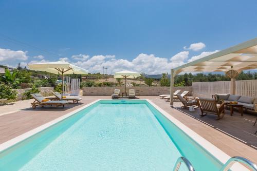 una piscina con sedie e un patio con di Anesis Villa, with Private Pool & BBQ, By ThinkVilla ad Adelianos Kampos
