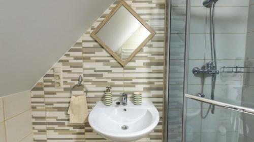 a bathroom with a sink and a mirror at Csodaszarvas Vendégházak in Rábahidvég