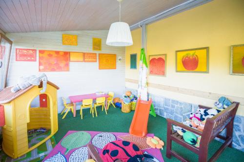 a room with a play room with a table and chairs at Hotel SLUNEČNÁ LOUKA in Lipno nad Vltavou