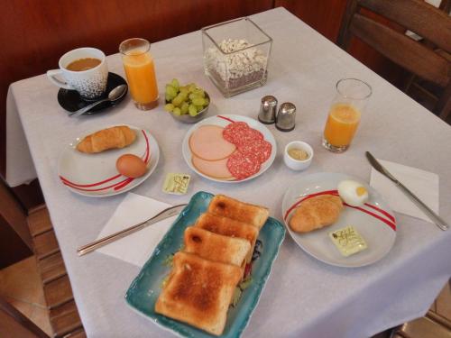 a table topped with plates of breakfast foods and orange juice at Archontiko Klitsa in Portariá