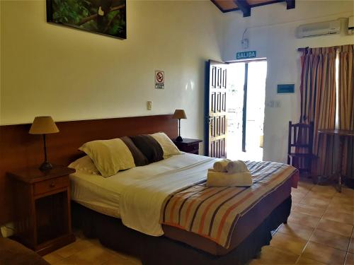 Un dormitorio con una cama con un osito de peluche encima. en Si Mi Capitán - Cabañas & Habitaciones, en Puerto Iguazú