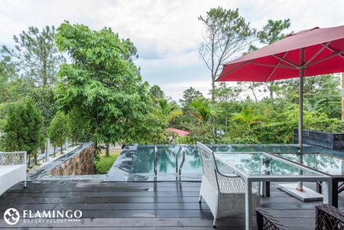 a patio with a table and an umbrella at FLAMINGOS Villa Happy 3 phòng ngủ- view Hồ- bể bơi riêng in Ngọc Quang
