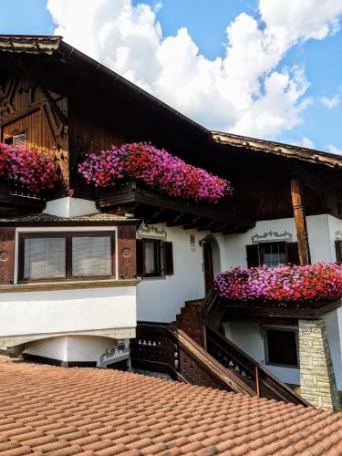 une maison avec des boîtes de fleurs sur son côté dans l'établissement Schnellehof, à Velturno