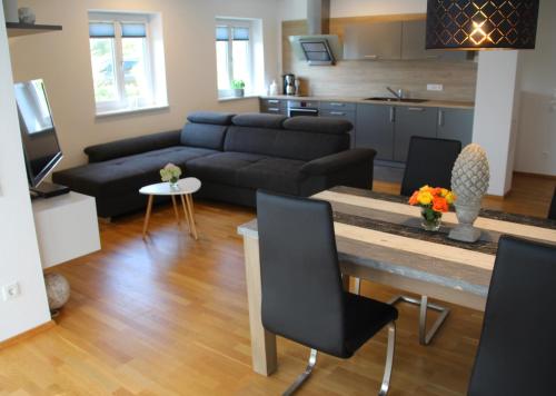 uma sala de estar com um sofá e uma mesa em Chiemsee-Edelweiß Ferienwohnung em Prien am Chiemsee