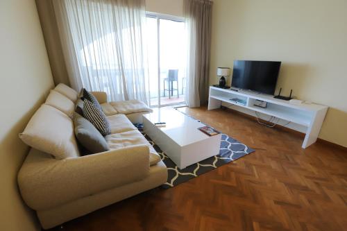 a living room with a couch and a flat screen tv at The Straits Quay Marina by Messina Clive in George Town
