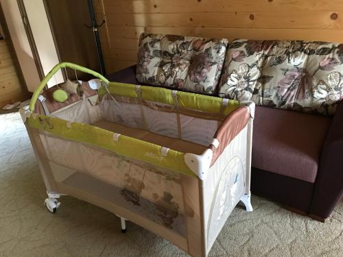 a crib in a room with a couch at Georgiy in Oryavchyk