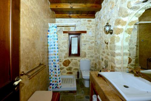 a bathroom with a sink and a toilet and a shower curtain at Kiparissi Villa Halkidiki in Ierissos