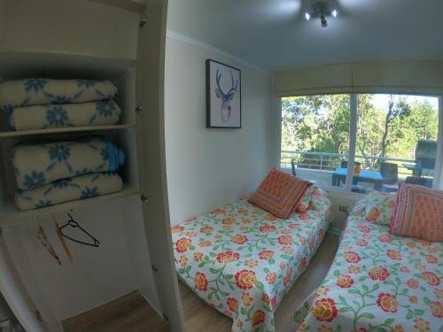 a bedroom with two beds and a window at Departamento reñaca bosque in Viña del Mar
