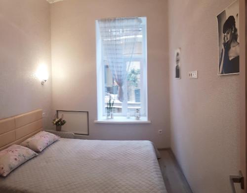 a bedroom with a bed and a window at Apartment - Heart of Odessa in Odesa
