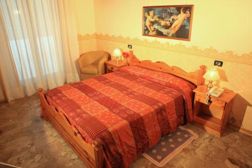 a bedroom with a large bed and a chair at Hotel Centrale in Gambarie dʼAspromonte
