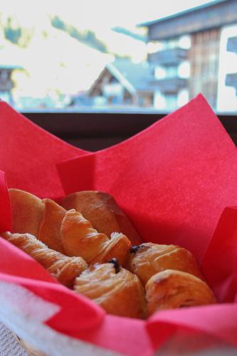 een rode mand met gebakjes staat op een tafel bij Hotel Le Christiania in Les Gets