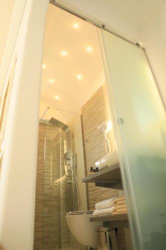 y baño con ducha, lavabo y espejo. en Theasis Luxury Suites, en Schinoussa