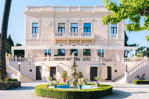 a large white building with a fountain in front of it at Casa de los Bates in Motril