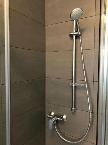 een douche met een douchekop in de badkamer bij Downtown City - PrivateRooms in Fürth