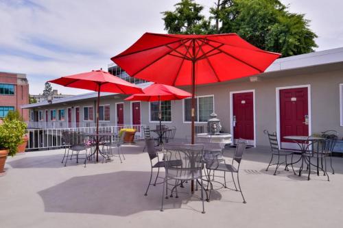 a patio with tables and chairs with red umbrellas at Campus Inn & Suites Eugene Downtown in Eugene