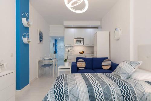 una camera con letto blu e una cucina di Casa Ocean Breeze a Las Palmas de Gran Canaria
