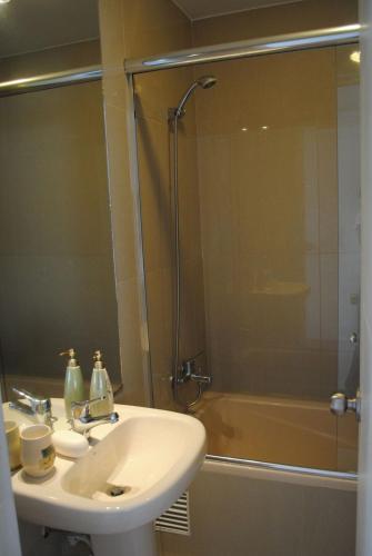a bathroom with a sink and a shower at Beachfront Condo San Miguel in Lima