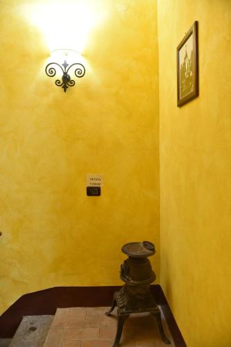 a room with a yellow wall with a light at Il Palazzetto B&B in Viterbo
