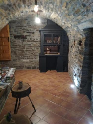 a living room with a fireplace in a stone wall at Apartamento Casa Dueso in El Pueyo de Araguás