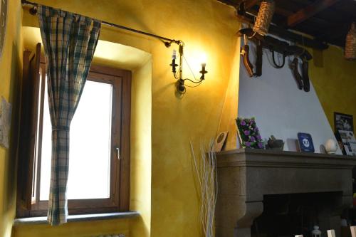 ein Wohnzimmer mit einem Kamin und einem Fenster in der Unterkunft Il Palazzetto B&B in Viterbo