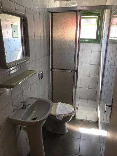 a bathroom with a toilet and a sink and a shower at Pousada Casa Doce Vida in Águas de Lindóia