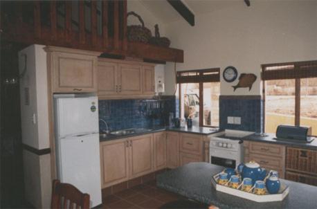 Il comprend une cuisine équipée d'un réfrigérateur blanc et d'une table. dans l'établissement Royal Coachman, à Clarens