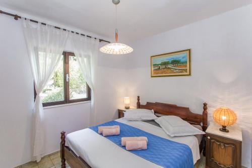 a bedroom with a bed with two pillows on it at Beachside Villa Marko in Milna