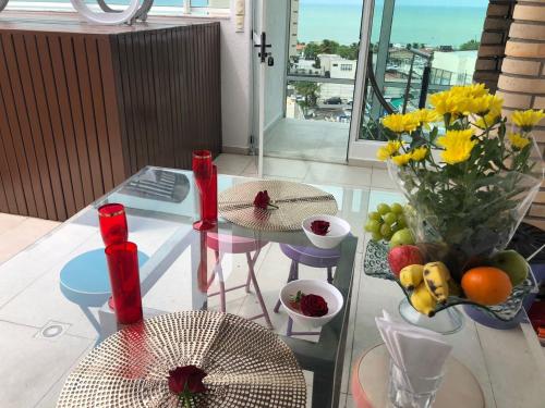 una mesa de cristal con un jarrón de flores en el balcón en Marina Bezerril - Cobertura Lemon Flat - A melhor de Ponta Negra, en Natal